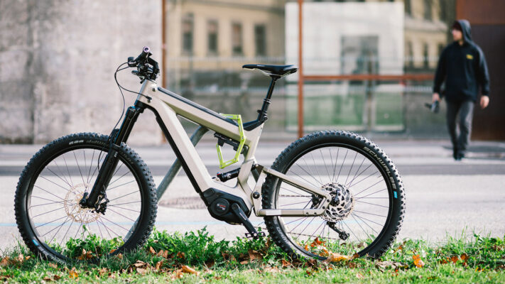 Dieb nähert sich einem E-Bike, das mit einem Faltschloss an Straßenständer angeschlossen ist.